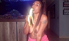 Desi dekle vadi svoje oralne sposobnosti na banani, medtem ko razkazuje svoje majhne prsi