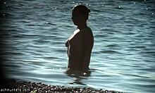 Gadis berpayudara besar dengan tubuh semulajadi berjalan-jalan di pantai nudis