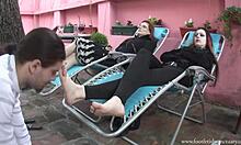 Dua gadis bersantai di recliners dan kaki mereka dijilat