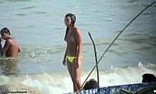 Bombe topless montrant ses seins fermes sur une plage nudiste