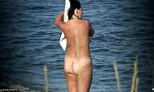 Přirozená prsa nudistky ukazují své tělo na opuštěné nudistické pláži