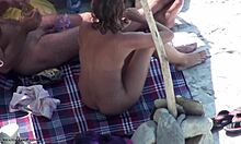 Красивая брюнетка в тенях демонстрирует свое голое тело на нудистском пляже