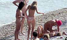 Kinky nakna flickvänner pratar med varandra och är stygga på en strand