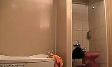 Ohromující žena relaxuje pod sprchou a je sledována
