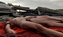 Un cuplu francez se angajează în masturbare reciprocă pe o plajă publică de nudiști din Grecia, cu conținut explicit