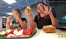 Две сексуально возбужденные женщины обнажают свои груди во время обеда в Макдональдсе с профессионально татуированным ангелом
