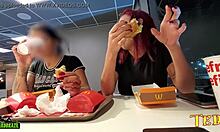 Két szexuálisan izgatott nő mellei ki vannak téve, miközben McDonalds-ban étkeznek - egy profi módon tintával ellátott angyallal