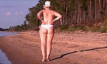 Wulpse rijpe vrouw pronkt met haar rondingen in een witte zwembroek