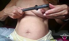 Madre pervertida con piercings en los pezones estirados disfruta de una inserción de varilla de 16 mm en un video casero