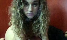 O fată blondă drăguţă cu sâni mari îţi face sex oral în timp ce fumează o ţigară